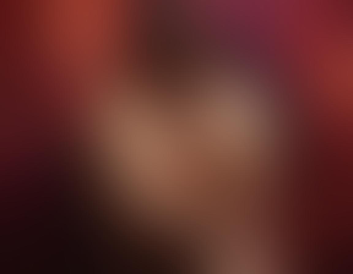 A sensual and elegant scene featuring intertwined silhouettes of a couple in a passionate embrace, with soft and warm lighting casting gentle shadows. Surround them with abstract floral patterns and soft, flowing fabrics to evoke a sense of romance and intimacy. Incorporate rich hues of red, gold, and deep purple to enhance the erotic atmosphere. super-realistic. vibrant colors. soft focus.